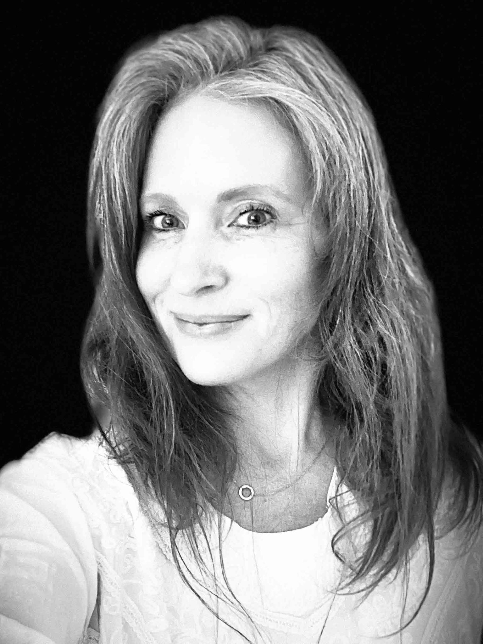 Lowly Labs team member Tara B, smiling in a black and white selfie.